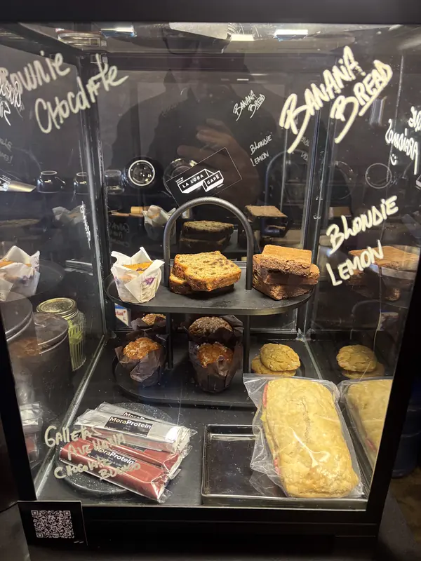Vitrina con brownies, muffins, banana bread y lemon blondie, rotulados a mano en el vidrio